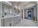 Bright main bathroom with dual sinks, gray cabinets, stylish mirrors, and a walk-in shower, offering a spa-like experience at 2171 Deadwood St, Pahrump, NV 89048