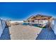 Backyard oasis featuring a sparkling pool, spa, and shaded pergola seating area perfect for outdoor entertaining at 2171 Deadwood St, Pahrump, NV 89048