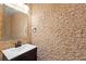 Powder room featuring a stylish vanity and textured stone accent wall at 224 Devotion Ct, Henderson, NV 89052