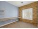 Cozy bedroom featuring a built-in desk, a stone accent wall, and natural light at 224 Devotion Ct, Henderson, NV 89052
