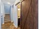 Hallway view featuring stone floors, stairs, and a wooden barn door leading to a bathroom at 224 Devotion Ct, Henderson, NV 89052