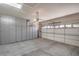 Spacious garage with built-in storage cabinets and a roll-up door for convenient vehicle parking at 2539 Stardust Valley Dr, Henderson, NV 89044