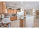 Well-lit kitchen featuring oak cabinets, a breakfast bar, and tile backsplash at 2539 Stardust Valley Dr, Henderson, NV 89044
