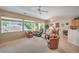 Bright living room featuring large windows with backyard views, tile floors, and ample seating at 2539 Stardust Valley Dr, Henderson, NV 89044