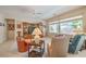 Cozy living room with large windows, wood entertainment center, and comfortable seating arrangement at 2539 Stardust Valley Dr, Henderson, NV 89044