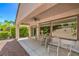 Covered outdoor patio with a ceiling fan and ample seating overlooking the landscaped backyard at 2539 Stardust Valley Dr, Henderson, NV 89044