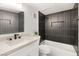 Modern bathroom featuring black tile, a soaking tub, and a bright white vanity at 2838 Geary Pl # 4002, Las Vegas, NV 89109