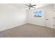 This airy bedroom has carpet, a ceiling fan, and a window with neighborhood views at 2838 Geary Pl # 4002, Las Vegas, NV 89109