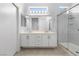 Bright bathroom featuring double vanity, large mirror, and glass-enclosed shower at 2999 Gettysburg Ave, Henderson, NV 89052