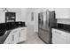 Modern kitchen featuring stainless steel refrigerator, black countertops, and white cabinets at 2999 Gettysburg Ave, Henderson, NV 89052