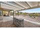 Covered patio with an outdoor fireplace, desert landscaping, and a view at 2999 Gettysburg Ave, Henderson, NV 89052