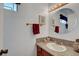 Powder room with wooden cabinets, granite countertops, round mirror, and brushed gold hardware at 3380 Pavlo St, Las Vegas, NV 89121