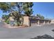 Row of garages with beige doors, set against a backdrop of lush greenery and clear blue sky at 3380 Pavlo St, Las Vegas, NV 89121