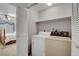 Cozy laundry room features a washer, dryer, shelving, and access to the main bedroom at 3380 Pavlo St, Las Vegas, NV 89121