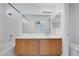 Bright bathroom with a white tub and shower combination, a large mirror, and a spacious wooden vanity at 3644 Shanagolden St, Las Vegas, NV 89129