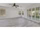 Bright bedroom features wood-look flooring, ceiling fan, and sliding glass door to a patio at 3644 Shanagolden St, Las Vegas, NV 89129