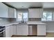 Modern kitchen with stainless steel appliances, white cabinets, and a window overlooking the front yard at 3700 Hickey Ave, North Las Vegas, NV 89030