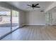 Bright living room featuring new vinyl floors, ceiling fan, and sliding glass door to the outdoor space at 3700 Hickey Ave, North Las Vegas, NV 89030