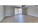 Open-concept living room with vinyl flooring, neutral paint, and sliding glass doors to a covered patio at 3700 Hickey Ave, North Las Vegas, NV 89030