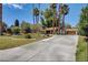 Spacious home with a long driveway and lush landscaping with mature palm trees at 4012 Vegas Dr, Las Vegas, NV 89108