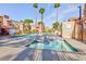 Condo community pool with a connected hot tub, lounge area, and mature palm trees at 4050 Pacific Harbors Dr # 112, Las Vegas, NV 89121