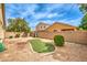 View of backyard with patio, firepit, low brick wall, mature trees, and grass at 4071 Blue Manor Ln, North Las Vegas, NV 89032
