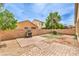 Landscaped backyard with patio, firepit, rock ground cover, and low brick wall at 4071 Blue Manor Ln, North Las Vegas, NV 89032