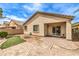 View of backyard featuring a low wall, small grass area, and brick patio with covered patio at 4071 Blue Manor Ln, North Las Vegas, NV 89032