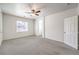 Carpeted bedroom features a ceiling fan, bright window, and ensuite access at 4071 Blue Manor Ln, North Las Vegas, NV 89032