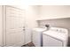 Efficient laundry room with a washer, dryer, door to outside, and a convenient shelf at 4071 Blue Manor Ln, North Las Vegas, NV 89032
