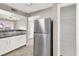 Well lit kitchen with white cabinets, stainless steel refrigerator, and wood look flooring at 45 Maleena Mesa St # 1424, Henderson, NV 89074