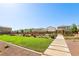 Beautiful community park with green grass, playground equipment and a walking path at 4630 Adonis Blue St, North Las Vegas, NV 89031