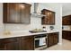 Modern kitchen features stainless steel range hood, quartz countertops, and dark wood cabinets at 4630 Adonis Blue St, North Las Vegas, NV 89031