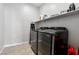 This laundry room includes washer, dryer, and storage shelving for convenience at 4630 Adonis Blue St, North Las Vegas, NV 89031