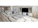 Open-concept living room featuring a large sectional sofa, custom entertainment center, and stylish décor at 4630 Adonis Blue St, North Las Vegas, NV 89031
