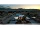 Twilight aerial shot captures a single story home, basketball court, outbuilding, and mountains in the distance at 5315 N Fort Apache Rd, Las Vegas, NV 89149