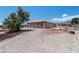 Exterior of the home features desert landscaping with a gravel yard and an antique horse drawn wagon at 5315 N Fort Apache Rd, Las Vegas, NV 89149