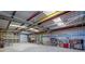 Interior view of the garage, featuring colorful beams, roll-up doors, shelving, and various items at 5315 N Fort Apache Rd, Las Vegas, NV 89149