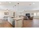 Open concept kitchen features a center island with sink, seating, granite countertops and stainless appliances at 5315 N Fort Apache Rd, Las Vegas, NV 89149