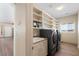 Well-equipped laundry room features updated washer/dryer, utility sink, and built-in shelves for storage at 5315 N Fort Apache Rd, Las Vegas, NV 89149