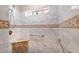 Shower features marble-look tile, a built-in seat, and decorative accent tiles, plus grab bars for safety at 5315 N Fort Apache Rd, Las Vegas, NV 89149