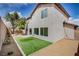 A backyard featuring lush green grass, desert landscaping, and a low block wall for privacy at 5345 Tustin Hills St, North Las Vegas, NV 89081