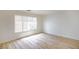 Sunlit bedroom boasts modern wood-look flooring and a large window with bright, natural light at 5345 Tustin Hills St, North Las Vegas, NV 89081
