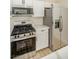 Kitchen with stainless steel appliances including a range and a refrigerator with white cabinetry at 5345 Tustin Hills St, North Las Vegas, NV 89081