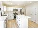 Bright kitchen featuring an island, stainless steel appliances, white cabinets and quartz countertops at 5345 Tustin Hills St, North Las Vegas, NV 89081