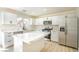 Bright kitchen featuring an island, stainless steel appliances, white cabinets and quartz countertops at 5345 Tustin Hills St, North Las Vegas, NV 89081