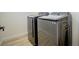 Laundry room features side by side modern black washer and dryer on wood-look flooring at 5345 Tustin Hills St, North Las Vegas, NV 89081