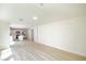 Spacious living room with wood-look flooring, leading to an open kitchen and dining area at 5345 Tustin Hills St, North Las Vegas, NV 89081