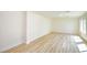 Bright, empty living room featuring wood-look flooring and natural light from a window at 5345 Tustin Hills St, North Las Vegas, NV 89081