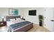 Bedroom features a king bed, mounted TV, and a plant that adds a natural element to the space at 5345 Tustin Hills St, North Las Vegas, NV 89081